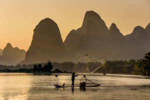 Cormorant Fisherman casting his net on Li River, Xingping, Photo Tour China
