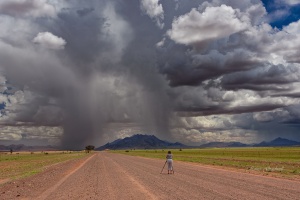 Photographer in dramatic landscape Namibia. Namibia photo tours